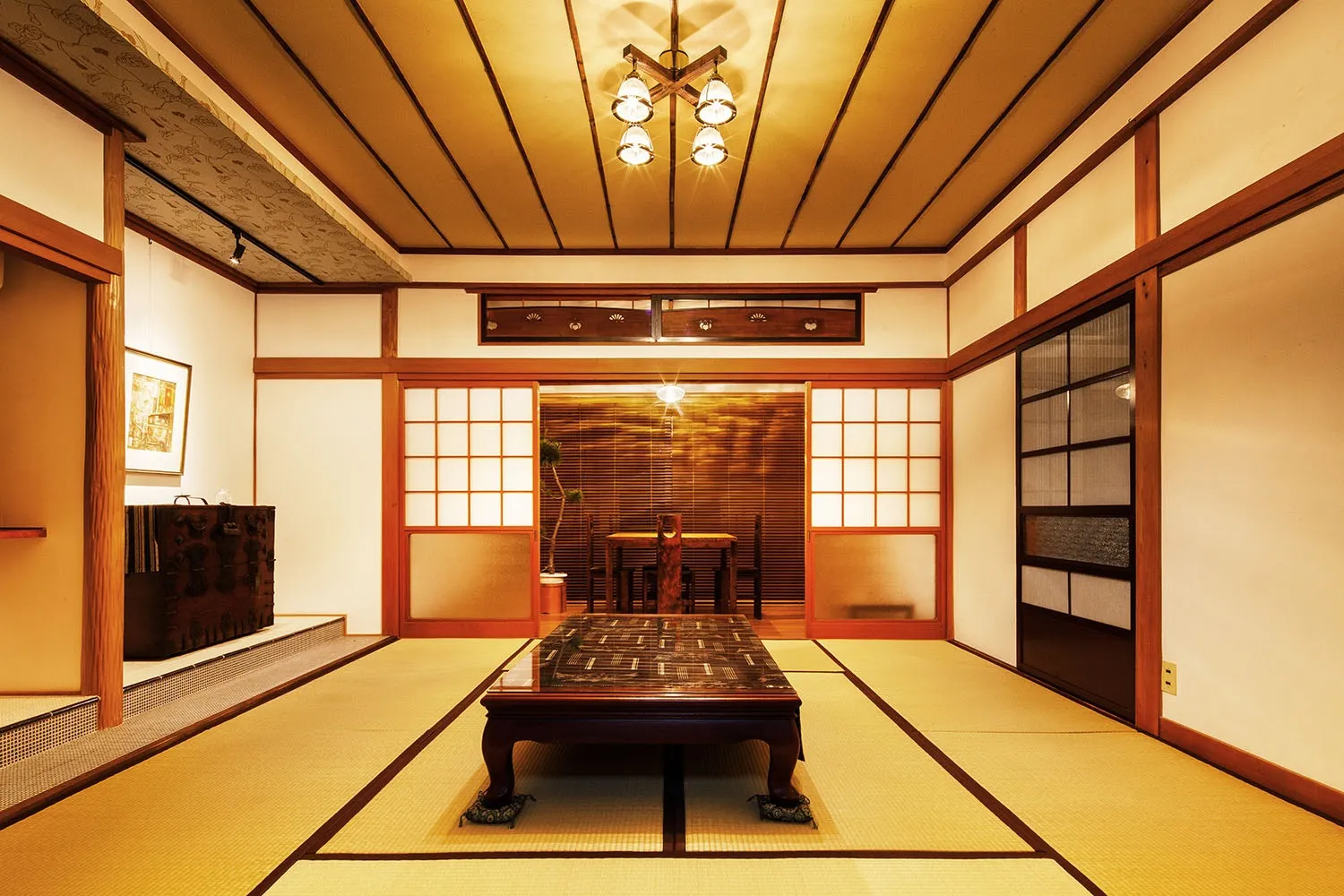 古い李朝時代の箪笥に油絵、京唐紙の天井にスス竹の竿、窯変タイルの床の間、無国籍客間。
