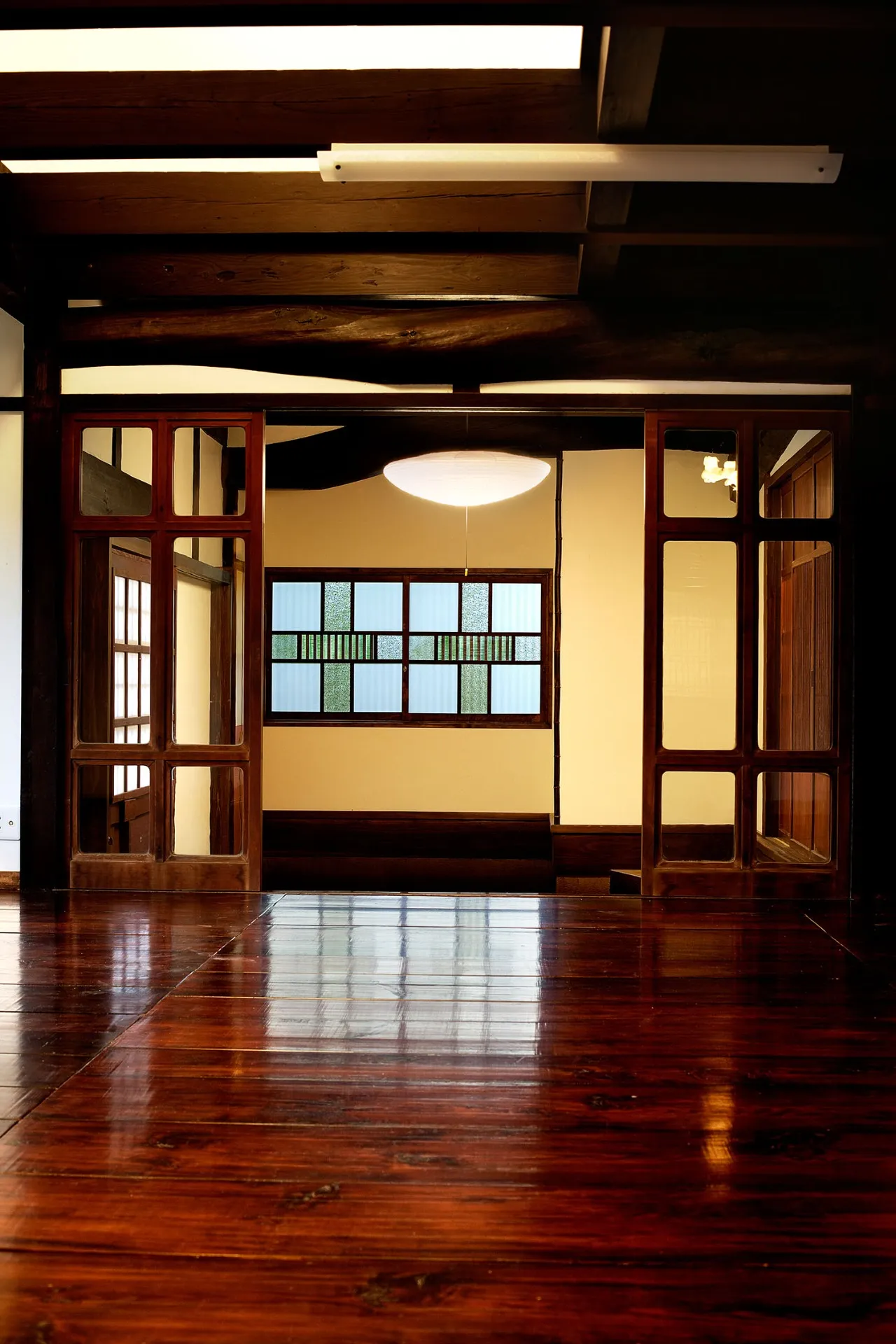 美しい格子のある窓ガラスは、そのままに利用して、リビングと和室を仕切る建具は、明治の古民家のものをリメイクして再利用しています。