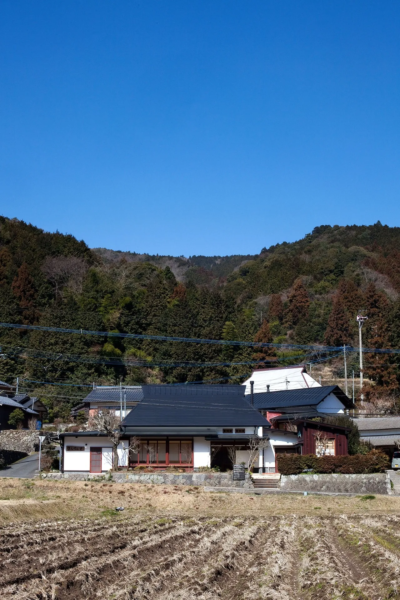 手を入れる前の民家は、茅葺きにトタン屋根をかぶせた納屋のような昔ながらの民家でしたが、今では、周りの景観にマッチしたおしゃれな古民家に生まれ変わりました。<br>美しくレイアウトされた外観と気品高く施された朱色の建具がこの民家の最大の見せ場になっています。
